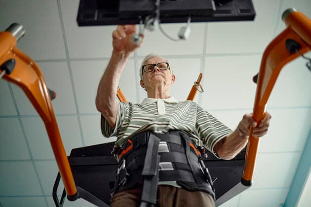 Senior man operates a rehabilitation machine in a clinic model released, Symbolfoto property released, KPEF01456