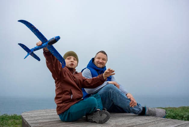 A father and son play with a toy airplane outdoors in the park model released, Symbolfoto, MBLF01262