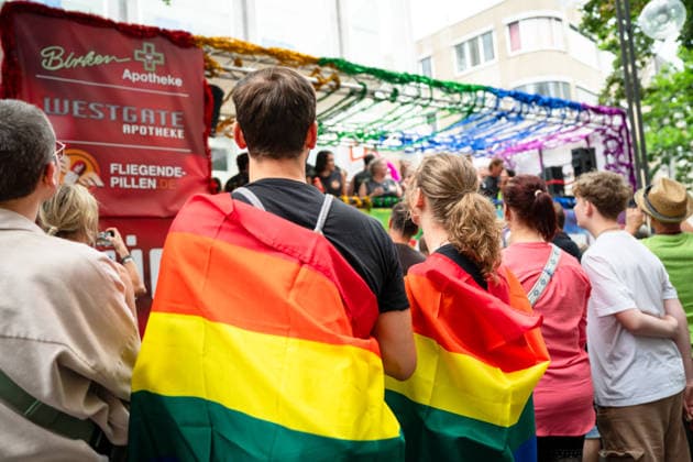 Christopher-Street-Day (CSD) in Koeln Zuschauer eingehuellt in Regenbogenflaggen feiern entlagn der CSD Demontration (Christopher-Street-Day) in Koeln fuer kulturelle Vielfalt der Pride Bewegung Koeln Nordrhein-Westfalen Deutschland *** Christopher Street Day (CSD) in Cologne: Spectators wrapped in rainbow flags celebrate along the route of the CSD parade on Christopher Street Day in Cologne, promoting cultural diversity within the Pride movement in Cologne, North Rhine-Westphalia, Germany