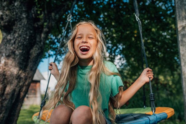 Laughing on a nest swing in the yard during a sunny summer day model released, Symbolfoto, NASF00234