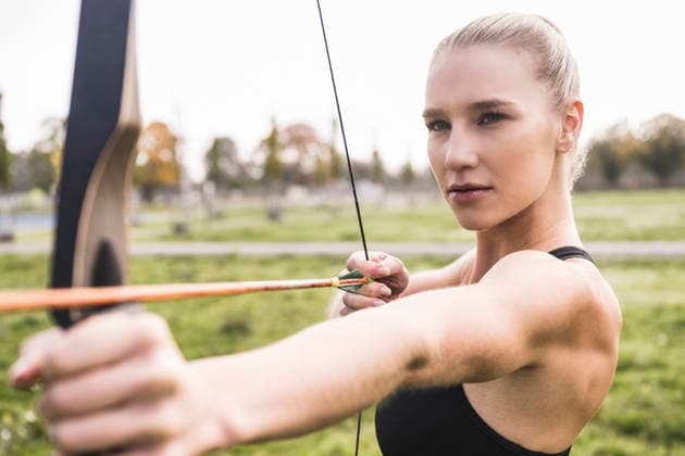 Confident athlete doing archery in meadow model released, Symbolfoto, UUF27811