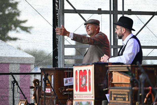 (260706) -- BERLIN, July 6, 2026 -- A barrel organ player (L) performs during the International Barrel Organ Festival 2026 in Berlin, Germany, July 5, 2026. The International Barrel Organ Festival 2026 was held in Berlin from July 3 to 5. Barrel organ players from across the world gathered here to entertain residents and visitors with a nostalgic musical celebration. ) GERMANY-BERLIN-BARREL ORGAN FESTIVAL ZhangxHaofu 