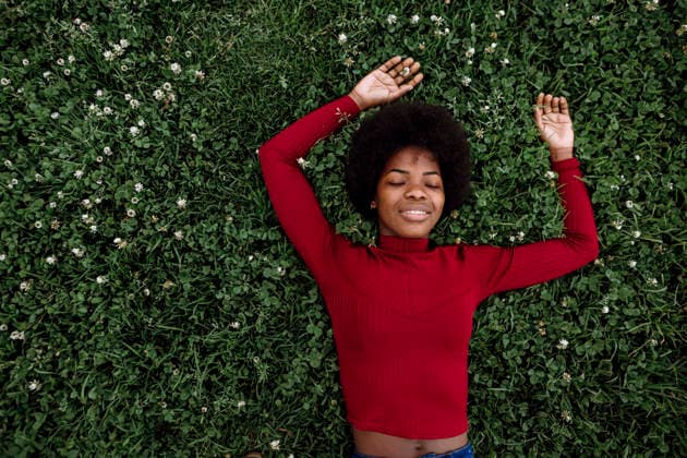 Young Afro woman with arms raised sleeping on grass model released, Symbolfoto, XLGF02027