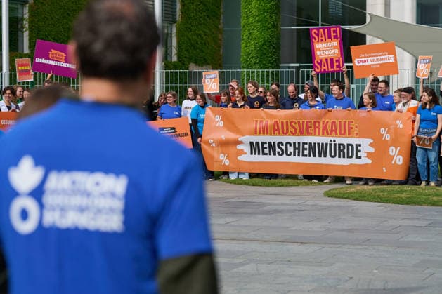 Ein Buendnis aus 15 Hilfsorganisationen protestiert am Montag (06.07.2026) vor dem Bundeskanzleramt in Berlin gegen Kuerzungen in der Entwicklungszusammenarbeit. Bei der Aktion Menschenwuerde im Ausverkauf fordern die Organisationen Aenderungen im Bundeshaushalt 2027. Dem Buendnis gehoeren unter anderem Brot fuer die Welt, misereor, Oxfam Deutschland sowie die Welthungerhilfe an. (Siehe epd-Meldung vom 06.07.2026) EDITORIAL USE ONLY *** A coalition of 15 aid organizations will protest on Monday, July 6, 2026, in front of the Federal Chancellery in Berlin against cuts to development cooperation. As part of the campaign Human Dignity on Sale, the organizations are calling for changes to the 2027 federal budget. The coalition includesinclu Copyright: epd-bild ChristianxDitsch D26D0706ProtestKuerzungEntwicklungshilfe092459
