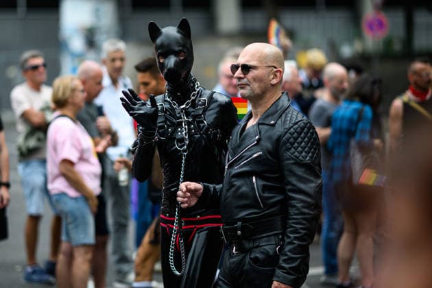 COLOGNE, GERMANY - 5 JULY, 2026: Two Pride parade participants in black leather and animal mask outfits pose among the crowd. Street Parade of the Christopher Street Day (CSD), Gay Pride. LGBT  Copyright: xx