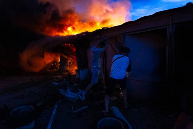 RECORD DATE NOT STATED Men stand beside garages engulfed in flames following a massive combined Russian attack, Kyiv, Ukraine, on July 6, 2026. Russian forces launched a large-scale attack on the capital using ballistic and cruise missiles as well as attack drones, causing destruction to apartment buildings and civilian infrastructure across several districts of the city. The Podilskyi district suffered the most severe damage. At least 11 people were killed and 46 others were injured (Photo by Kyrylo Chubotin Ukrinform) Russia launches another massive strike on Kyiv  Copyright: xKyryloxChubotinx
