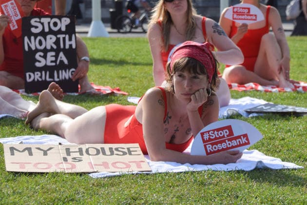 July 7, 2026, London, England, United Kingdom: Climate activists from the group Fossil Free London don swimming costumes and stage a Ã¢â‚¬Ëœsunbathe-inÃ¢â‚¬â ¢ protest dubbed Roast Against Rosebank in Parliament Square calling on the government to stop new North Sea oil and gas projects, as another heatwave hits the UK. London United Kingdom  - ZUMAv130 20260707_zip_v130_002 Copyright: xVukxValcicx
