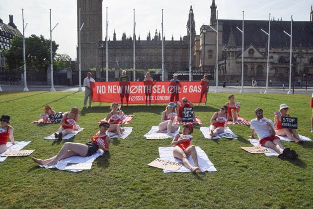 July 7, 2026, London, England, United Kingdom: Climate activists from the group Fossil Free London don swimming costumes and stage a Ã¢â‚¬Ëœsunbathe-inÃ¢â‚¬â ¢ protest dubbed Roast Against Rosebank in Parliament Square calling on the government to stop new North Sea oil and gas projects, as another heatwave hits the UK. London United Kingdom  - ZUMAv130 20260707_zip_v130_003 Copyright: xVukxValcicx