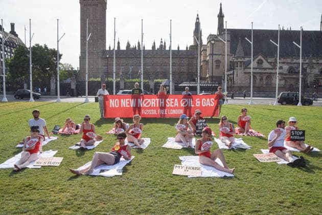 July 7, 2026, London, England, United Kingdom: Climate activists from the group Fossil Free London don swimming costumes and stage a Ã¢â‚¬Ëœsunbathe-inÃ¢â‚¬â ¢ protest dubbed Roast Against Rosebank in Parliament Square calling on the government to stop new North Sea oil and gas projects, as another heatwave hits the UK. London United Kingdom - ZUMAv130 20260707_zip_v130_007 Copyright: xVukxValcicx