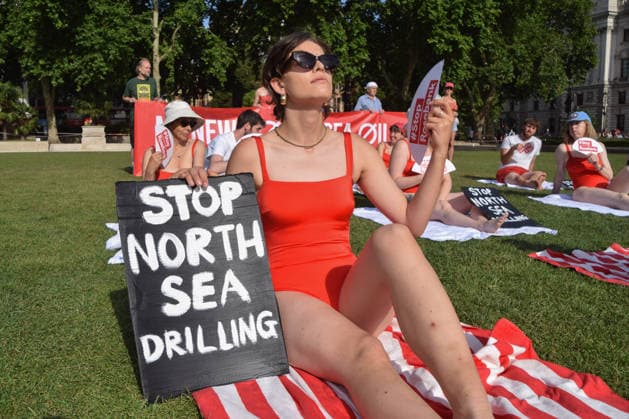 July 7, 2026, London, England, United Kingdom: Climate activists from the group Fossil Free London don swimming costumes and stage a Ã¢â‚¬Ëœsunbathe-inÃ¢â‚¬â ¢ protest dubbed Roast Against Rosebank in Parliament Square calling on the government to stop new North Sea oil and gas projects, as another heatwave hits the UK. London United Kingdom  - ZUMAv130 20260707_zip_v130_017 Copyright: xVukxValcicx