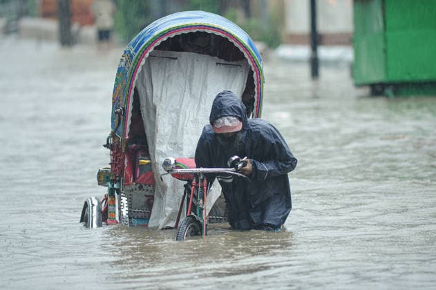 July 7, 2026: Chattogram, Bangladesh - A Rickshaw pullers navigate a waterlogged street in the Bahaddarhat area of Chattogram on Tuesday, continuing three consecutive days of heavy rainfall. The persistent downpours triggered severe waterlogging across several parts of the port city, submerging roads, disrupting traffic, and causing widespread inconvenience to residents. - ZUMAr143 20260707_zap_r143_013 Copyright: xMdxRafayatxHaquexKhanx