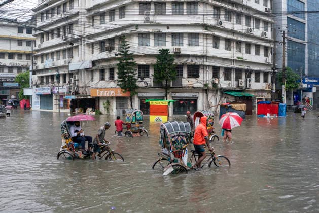 Bangladesh: Severe Waterlogging Paralyzes Chattogram Amid Heavy Monsoon Rain In Chattogram A general view shows rickshaws and pedestrians wading through an inundated intersection in front of commercial buildings in Chattogram, Bangladesh, on July 7, 2026. The prolonged waterlogging has disrupted economic activities and caused widespread civic distress in the port city. Chattogram Bangladesh  Copyright: xZakirxHossainx originalFilename: hossain-notitle260707_npXc4.jpg