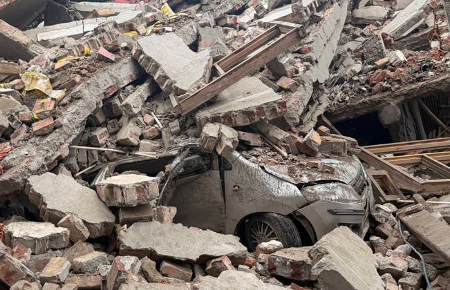 Under-Construction Building Collapses in New Delhi s Rohini Sector 16 New Delhi, Jul 08 (ANI): A view of a damaged vehicle trapped under the piles of rubble after an under-construction building collapsed at Rohini s Sector 16, in New Delhi on Wednesday. Firefighting and rescue operations underway. NEW DELHI Delhi India Copyright: xANIx ANI_20260708364