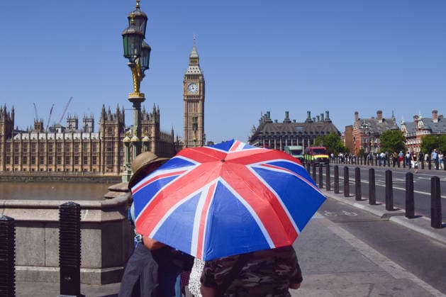 July 8, 2026, London, United Kingdom: A woman carries an umbrella to shield from heat as she walks on Westminster Bridge. London United Kingdom  - ZUMAs197 20260708_aab_s197_006 Copyright: xVukxValcicx