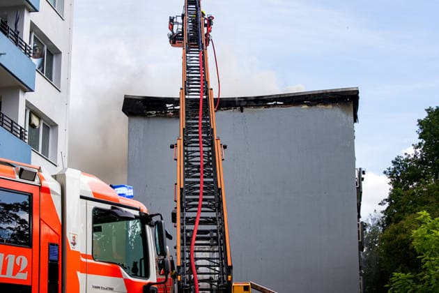 Wohnungsbrand greift auf Dachstuhl über Dach auf 60 mal 10 Metern in Vollbrand Am 08.07.2026 kam es in Frankfurt-Schwanheim gegen 15:50 Uhr zu einem Wohnungsbrand im dritten Obergeschoss eines Mehrfamilienhauses, der noch vor Eintreffen der Feuerwehr auf den Dachstuhl übergriff. Die Berufsfeuerwehr und die Freiwillige Feuerwehr Frankfurt bekämpften den Dachbrand auf einer Fläche von 60 mal 10 Metern mit acht Rohren vom Boden sowie über vier Drehleitern. Aufgrund der Thermik zog der Rauch nicht ab, sondern breitete sich über umliegende Straßen aus, weshalb die Polizei per Lautsprecher zum Schließen von Fenstern und Türen aufrief und zusätzlich über Medien gewarnt wurde. Die Brandwohnung brannte komplett aus und ist nicht mehr