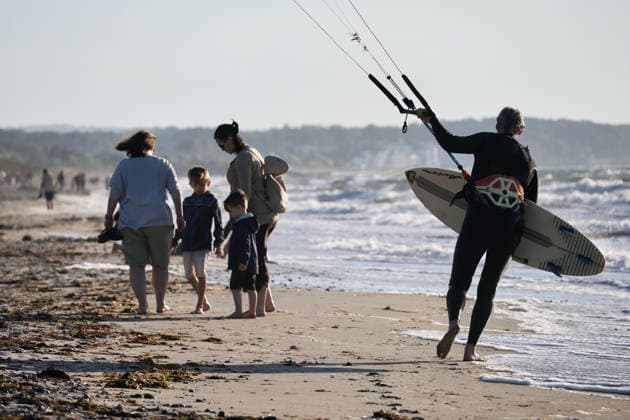 20260708 Strandidylle an der Ostsee bei Börgerenede-Rethwisch, einer Gemeinde im Landkreis Rostock in Mecklenburg-Vorpommern. Touristen und Urlauber flannieren am Strand, sitzen in Campingstühlen, bauen Sandburgen und suchen Bernstein. Sogar Kitesurfer gehen bei dem Wellengang auf dem Wasser ihrem Sport nach. Börgerende-Rethwisch Mecklenburg-Vorpommern Deutschland *** 20260708 A picturesque beach scene on the Baltic Sea near Börgerende Rethwisch, a municipality in the Rostock district of Mecklenburg-Western Pomerania. Tourists and vacationers stroll along the beach, sitting in camping chairs, building sandcastles, and searching for amber. Even kitesurfers are enjoying their sport on the water amid the waves. Börgerende Rethwisch, Mec
