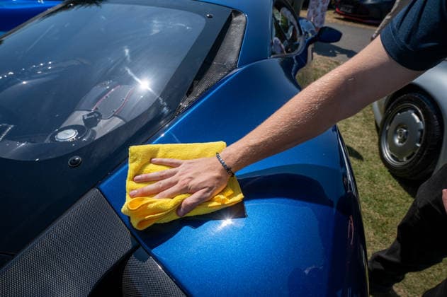 July 8, 2026, Epsom, Surrey, United Kingdom: A cleaner wipes the the rear of a 2017 blue Ferrari FXX-EVO, during the 2026 RAC Woodcote Concours. The Royal Automobile Club hosted its second Concours at Woodcote Park in Epsom. More than 50 exceptional vehicles, representing over a century of motoring history, were displayed across the estate. The collection included veteran, vintage, classic, racing and supercars, as well as an impressive selection of motorcycles. Epsom United Kingdom - ZUMAs197 20260708_aaa_s197_108 Copyright: xJamesxWilloughbyx
