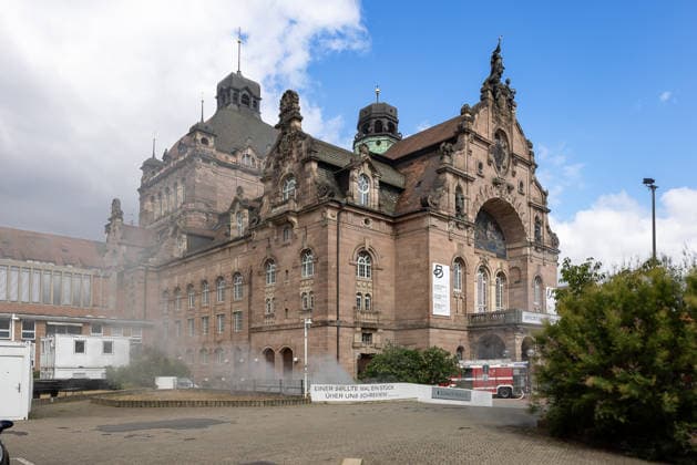 Feuerwehr-Großeinsatz am Nürnberger Opernhaus nach Brand in Tiefgarage, Nürnberg, 09.07.2026 Rauch steigt aus den Lüftungsschächten des Staatstheaters Nürnberg auf, nachdem ein Fahrzeugbrand in der angrenzenden Tiefgarage auf weitere Autos übergegriffen hat. Die Feuerwehr hat den Brand weitgehend unter Kontrolle, kämpft jedoch noch gegen die starke Rauchentwicklung. Das Gebäude wurde evakuiert, Statiker prüfen die Gebäudestruktur nach der Hitzeeinwirkung. Nürnberg Bayern Deutschland *** Large-Scale Firefighting Operation at the Nuremberg Opera House Following a Fire in the Underground Parking Garage, Nuremberg, July 9, 2026 Smoke is rising from the ventilation shafts of the Nuremberg State Theater, after a vehicle fire in the a 20260709-286A1350-M4000
