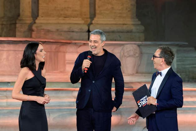 July 8, 2026, Rome, Rome, Italy: Hosts Gloria Campaner, left, and Pino Strabioli, right, with last year s winner Andrea Bajani, during the final evening of the eightieth edition of the Strega Prize literary competition in Piazza del Campidoglio, Rome, July 8, 2026. Rome Italy  - ZUMAa289 20260708_zia_a289_255 Copyright: xRiccardoxDexLucax xAgfx
