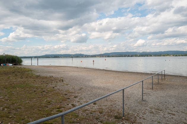 Iznang Niedrigwasser am Bodensee bei Iznang Iznang, Baden-Württemberg, Deutschland Niedriger Wasserstand am Bodensee beim Strandbad Iznang am Untersee. Eine Person läuft weit draußen durch das flache Wasser, während am Ufer große freiliegende Kies und Uferflächen sichtbar sind. Das Bild zeigt deutlich, wie weit sich das Wasser am Bodensee durch den niedrigen Pegelstand zurückgezogen hat. 08.07.2026. Editorial use only. *** Iznang Low Water Level on Lake Constance near Iznang Iznang, Baden-Württemberg, Germany Low water level on Lake Constance near the Iznang beach on the Untersee A person is walking far out in the shallow water, while large areas of exposed gravel and shoreline are visible along the shore. The image clearly show Copyright: xEibner-Pressefotox EP_EER