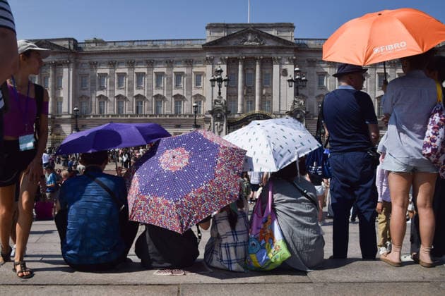 July 9, 2026, London, England, United Kingdom: People shield from the scorching sun under umbrellas outside Buckingham Palace as the UK is hit by another heatwave. London United Kingdom  - ZUMAv130 20260709_zip_v130_012 Copyright: xVukxValcicx