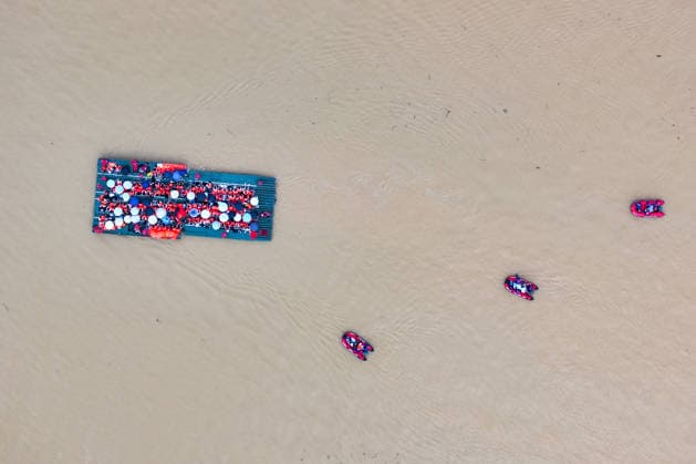 (260709) -- NANNING, July 9, 2026 -- An aerial drone photo shows rescuers evacuating trapped students on a powered pontoon bridge in Guigang City, south China s Guangxi Zhuang Autonomous Region, July 9, 2026. Recent extreme rainstorms triggered by Typhoon Maysak, the 10th typhoon of the year, have caused severe flooding in parts of Guangxi in the Pearl River basin. Guangxi is continuing its search and rescue operations for missing persons, enhancing resettlement services for affected residents and advancing post-disaster reconstruction. ) FOCUS Guangxi makes all-out rescue, relief efforts after rain-triggered disasters ZhouxHua 