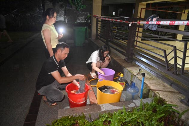 (260710) -- GUIGANG, July 10, 2026 -- Residents do laundry at a water supply point at a community in Guigang, south China s Guangxi Zhuang Autonomous Region, July 9, 2026. Guigang has suffered severe flooding due to torrential rains brought by Typhoon Maysak and upstream inflows. Local authorities have mobilized rescue forces to work around the clock, making every effort to ensure basic living needs for stranded residents. ) CHINA-GUANGXI-GUIGANG-TYPHOON-FLOOD-RESCUE (CN) ZhouxHua 