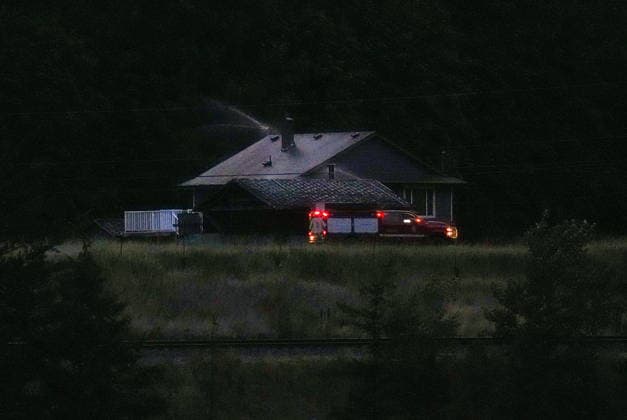 July 9, 2026, Boston Bar, Bc, CANADA: Firefighters drive past a house with sprinklers deployed on the roof at the base of a mountain where the Brunswick Creek wildfire is burning, in North Bend, B.C., on Thursday, July 9, 2026. Boston Bar CANADA  - ZUMAc35_ 20260709_zaf_c35_107 Copyright: xDarrylxDyckx