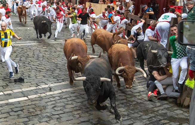 The fighting bulls from the ranch of Alvaro Nunez stampede through the Old City streets in the fourth running-of-the-bulls in Pamplona, northern Spain on Friday, July 20, 2026. Several runners were injured the morning but none were gored.  PAM20260710115 JimxHollander