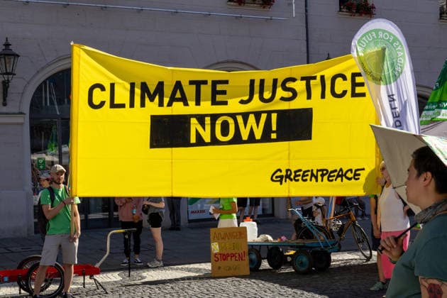Augsburg, Bavaria, Germany - July 10, 2026: Demonstration by the climate justice movement Fridays for Future and Greenpeace in Augsburg. Under the nationwide slogan: Protect the climate, fire the rich, the activists are protesting, among other things, against current gas infrastructure policy and planned gas drilling in Bavaria. GREENPEACE banner: CLIMATE JUSTICE NOW! *** Demonstration der Klimaschutzbewegung Fridays for Future und GREENPEACE in Augsburg. Unter dem bundesweiten Motto: Klima schützen, Reiche entlassen, protestieren die Aktivisten unter anderem gegen die aktuelle Gas-Infrastrukturpolitik und geplante Gasbohrungen in Bayern. GRENNPEACE Banner: CLIMATE JUSTICE NOW! Klimajustiz jetzt!