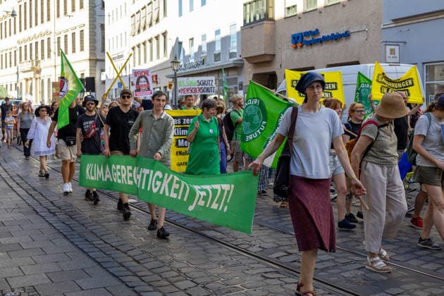 Augsburg, Bavaria, Germany - July 10, 2026: Demonstration by the climate justice movement Fridays for Future and Greenpeace in Augsburg. Under the nationwide slogan: Protect the climate, fire the rich, the activists are protesting, among other things, against current gas infrastructure policy and planned gas drilling in Bavaria. Protest march with a banner reading: CLIMATE JUSTICE NOW! *** Demonstration der Klimaschutzbewegung Fridays for Future und GREENPEACE in Augsburg. Unter dem bundesweiten Motto: Klima schützen, Reiche entlassen, protestieren die Aktivisten unter anderem gegen die aktuelle Gas-Infrastrukturpolitik und geplante Gasbohrungen in Bayern. Demozug mit Banner: KLIMAGERECHTIGKEIT JETZT!