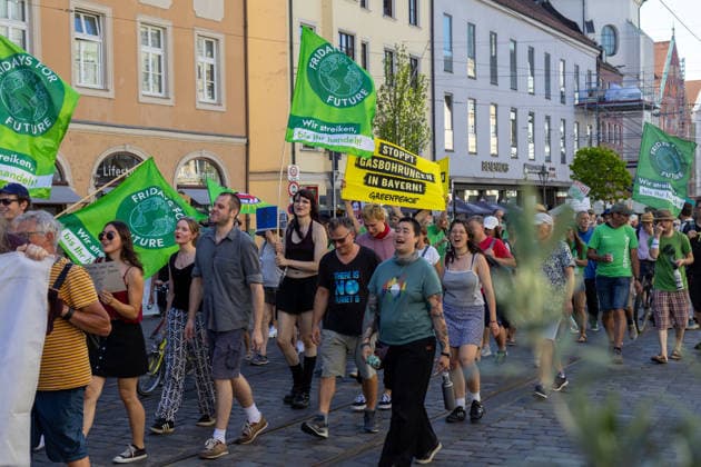 Augsburg, Bavaria, Germany - July 10, 2026: Demonstration by the climate justice movement Fridays for Future and GREENPEACE in Augsburg. Under the nationwide slogan: Protect the climate, fire the rich, the activists are protesting, among other things, against current gas infrastructure policy and planned gas drilling in Bavaria. Demonstrators march through the city carrying FFF flags and GREENPEACE signs: STOP GAS DRILLING IN BAVARIA! *** Demonstration der Klimaschutzbewegung Fridays for Future und GREENPEACE in Augsburg. Unter dem bundesweiten Motto: Klima schützen, Reiche entlassen, protestieren die Aktivisten unter anderem gegen die aktuelle Gas-Infrastrukturpolitik und geplante Gasbohrungen in Bayern. Demonstranten laufen durch
