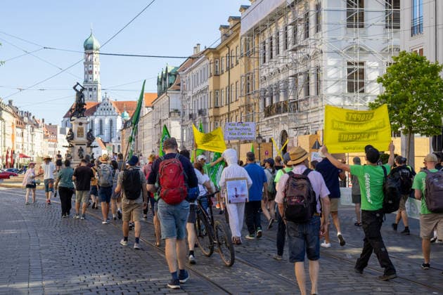 Augsburg, Bavaria, Germany - July 10, 2026: Demonstration by the climate justice movement Fridays for Future and GREENPEACE in Augsburg. Under the nationwide slogan: Protect the climate, fire the rich, the activists are protesting, among other things, against current gas infrastructure policy and planned gas drilling in Bavaria. Demonstrators march through the city carrying FFF flags and GREENPEACE signs: STOP GAS DRILLING IN BAVARIA! *** Demonstration der Klimaschutzbewegung Fridays for Future und GREENPEACE in Augsburg. Unter dem bundesweiten Motto: Klima schützen, Reiche entlassen, protestieren die Aktivisten unter anderem gegen die aktuelle Gas-Infrastrukturpolitik und geplante Gasbohrungen in Bayern. Demonstranten laufen durch