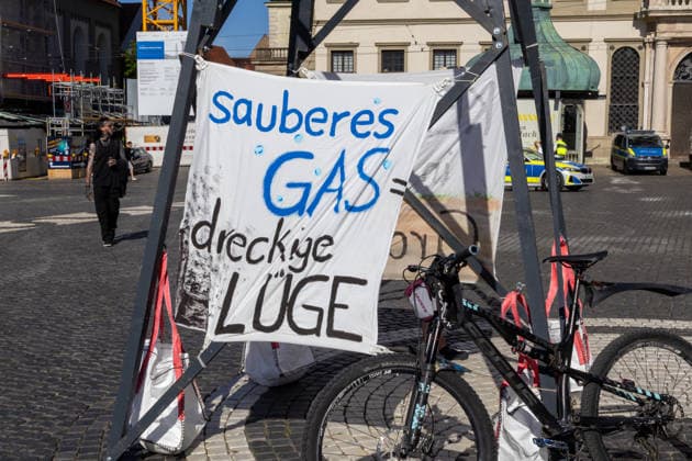 Augsburg, Bavaria, Germany - July 10, 2026: Demonstration by the climate justice movement Fridays for Future and Greenpeace in Augsburg. Under the nationwide slogan: Protect the climate, fire the rich, the activists are protesting, among other things, against current gas infrastructure policy and planned gas drilling in Bavaria. A symbolic drilling rig on Rahausplatz with a sign reading: CLEAN GAS IS A DIRTY LIE *** Demonstration der Klimaschutzbewegung Fridays for Future und GREENPEACE in Augsburg. Unter dem bundesweiten Motto: Klima schützen, Reiche entlassen, protestieren die Aktivisten unter anderem gegen die aktuelle Gas-Infrastrukturpolitik und geplante Gasbohrungen in Bayern. Symbolischer Bohrturm auf dem Rahausplatz mi