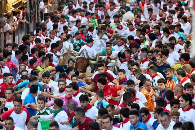San Fermin Festival in Spain PAMPLONA, SPAIN - JULY 11: Participants wearing traditional white outfits and red scarves take part in the running with the bulls event, known as Encierro, during the San Fermin Festival in Pamplona, northern Spain, on July 11, 2026. The adrenaline-filled run covers an 875-meter stretch through the historic city center. Ruben Albarran Anadolu Pamplona Spain. Editorial use only. Please get in touch for any other usage.  Copyright: x2026xAnadoluxRubenxAlbarranx