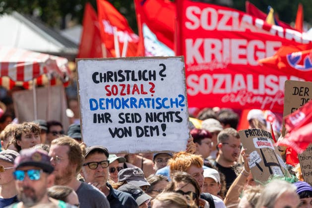Demonstration für Solidarität statt Sozialabbau, Nürnberg, 11.07.2026 Demonstranten des Bündnisses UNKÜRZBAR Mittelfranken protestieren gegen das Reformpaket der Bundesregierung. Ein Schild mit der Aufschrift Christlich? Sozial? Demokratisch? Ihr seid nichts von dem! dominiert im Vordergrund. Im Hintergrund sind rote Fahnen und weitere Protestschilder zu sehen. Nürnberg Bayern Deutschland *** Demonstration for Solidarity Instead of Social Cuts, Nuremberg, July 11, 2026: Protesters from the UNKÜRZBAR Middle Franconia coalition demonstrate against the federal government’s reform package. A sign reading Christian Social Democratic—You Are Not Dominated by Any of These is prominently displayed in the foreground. Red flags and other 20260711-1V9A5409-M4000