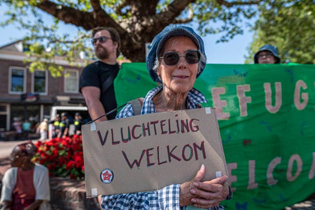 July 11, 2026, Schiedam, South Holland, Netherlands: 11 July 2026. A demonstrator holds a sign reading Refugees Welcome (translated from Dutch). In Schiedam, the Netherlands, a pro-asylum seeker demonstration promoted by Extinction Rebellion countered a demonstration called the Vrouwenmars tegen het AZC (Women s March Against the AZC) promoted by anti-asylum seeker centre groups. Both events took place in the center of Schiedam. Schiedam Netherlands - ZUMAp202 20260711_zip_p202_012 Copyright: xJamesxPetermeierx