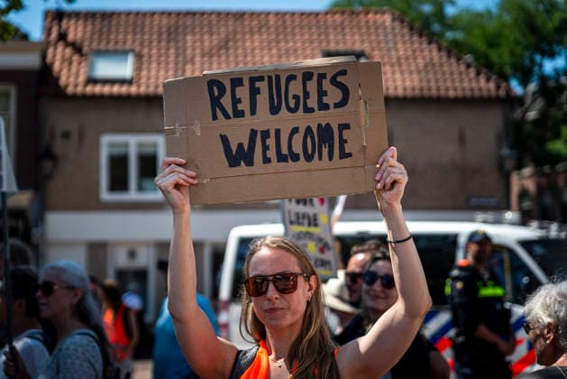July 11, 2026, Schiedam, South Holland, Netherlands: 11 July 2026. A demonstrator holds a sign reading Refugees Welcome. In Schiedam, the Netherlands, a pro-asylum seeker demonstration promoted by Extinction Rebellion countered a demonstration called the Vrouwenmars tegen het AZC (Women s March Against the AZC) promoted by anti-asylum seeker centre groups. Both events took place in the center of Schiedam. Schiedam Netherlands - ZUMAp202 20260711_zip_p202_016 Copyright: xJamesxPetermeierx