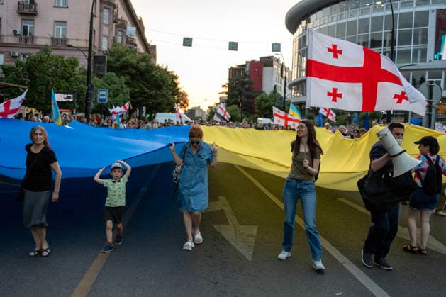 July 11, 2026, Tbilisi, Georgia: Protesters carry a large Ukrainian flag and wave Georgian flags as they mark 591st day of anti-government rally in Tbilisi, Georgia. Tbilisi Georgia - ZUMAz174 20260711_zip_z174_004 Copyright: xMoexZoyarix