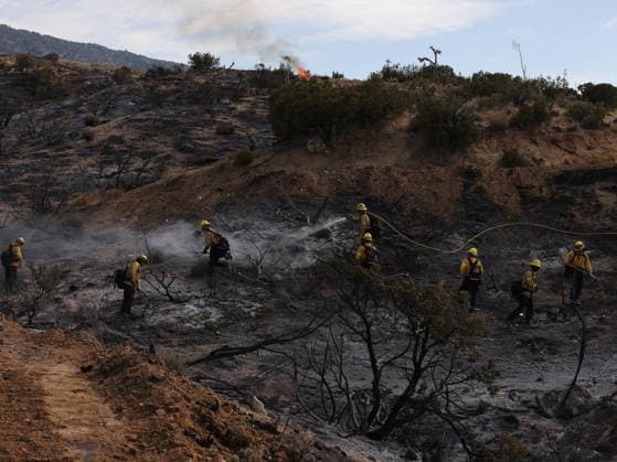 (260712) -- ANTELOPE VALLEY, July 12, 2026 -- Firefighters mop up debris after battling a brush fire in Antelope Valley, Los Angeles County, California, the United States, July 11, 2026. A wildfire burning in U.S. Southern California exploded to nearly 2,700 acres (about 10.9 square kilometers) Saturday, forcing evacuations amid dangerous heat wave. (Photo by Xinhua) U.S.-CALIFORNIA-LOS ANGELES COUNTY-WILDFIRE QiuxChen 