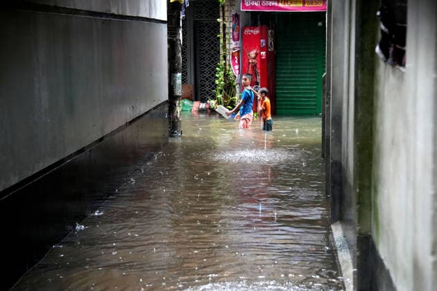 July 12, 2026, Dhaka, Dhaka, Bangladesh: Two boys walk through a waterlogged street during heavy monsoon rainfall in Dhaka, Bangladesh. Persistent downpours have inundated large parts of the capital, disrupting transportation and daily life as residents continue their routines despite widespread flooding. Dhaka Bangladesh  - ZUMAk174 20260712_zip_k174_002 Copyright: xSyedxMahabubulxKaderx