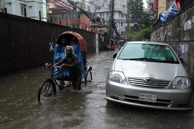 July 12, 2026, Dhaka, Dhaka, Bangladesh: A rickshaw puller pedals through a waterlogged street while carrying passengers during heavy monsoon rainfall in Dhaka, Bangladesh. Persistent downpours have inundated large parts of the capital, disrupting daily life and transportation, forcing residents to continue their routines despite widespread flooding. Dhaka Bangladesh  - ZUMAk174 20260712_zip_k174_012 Copyright: xSyedxMahabubulxKaderx