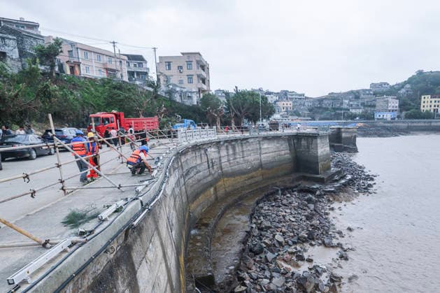 (260712) -- BEIJING, July 12, 2026 -- Steel frames are installed along a road where guardrails were blown down by strong winds in Yuhuan of Taizhou City, east China s Zhejiang Province, July 12, 2026. Typhoon Bavi, the ninth typhoon of the year, landed on the coast of east China s Zhejiang Province at around 11:20 p.m. Saturday, according to the Zhejiang provincial meteorological observatory. The typhoon, with the maximum wind force at its center reaching 40 meters per second when landing, first churned ashore at Yuhuan City, a county-level city administered by the city of Taizhou, before making a second landfall in Yueqing City under the city of Wenzhou at around midnight. After landfall, the typhoon is expected to continue moving n 