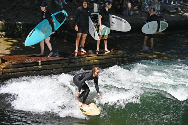 Wetterbild vom 12.07.2026 Surfer am Eisbach in Muenchen Hochbetrieb bei bestem Sommerwetter an der beruehmten Eisbachwelle im Englischen Garten in Muenchen. *** Weather photo from July 12, 2026: Surfers on the Eisbach in Munich. The famous Eisbach wave in Munich’s English Garden is bustling with activity amid perfect summer weather.
