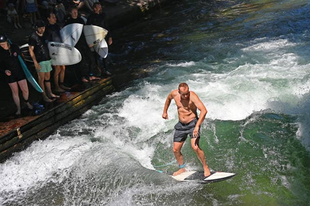 Wetterbild vom 12.07.2026 Surfer am Eisbach in Muenchen Hochbetrieb bei bestem Sommerwetter an der beruehmten Eisbachwelle im Englischen Garten in Muenchen. *** Weather photo from July 12, 2026: Surfers on the Eisbach in Munich. The famous Eisbach wave in Munich’s English Garden is bustling with activity amid perfect summer weather.