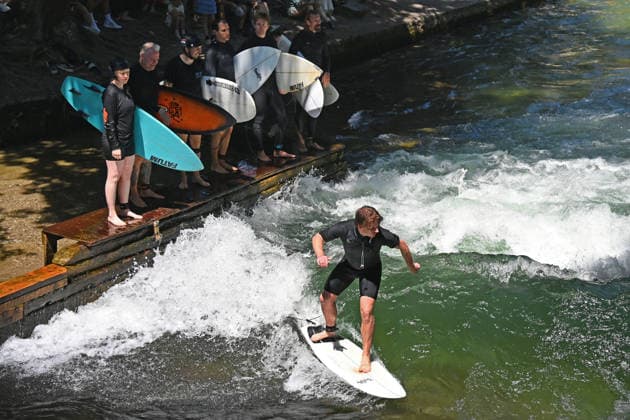 Wetterbild vom 12.07.2026 Surfer am Eisbach in Muenchen Hochbetrieb bei bestem Sommerwetter an der beruehmten Eisbachwelle im Englischen Garten in Muenchen. *** Weather photo from July 12, 2026: Surfers on the Eisbach in Munich. The famous Eisbach wave in Munich’s English Garden is bustling with activity amid perfect summer weather.