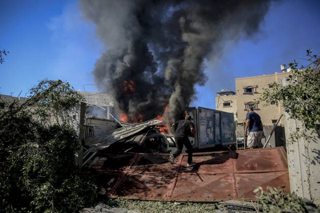 Israeli attacks on Gaza continue in violation of the ceasefire GAZA CITY, GAZA , PALESTINE - JULY 12: Palestinians rush as flame and thick smoke rise from a vehicle and destruction on Al-Sinaa (Industrial) Street in western Gaza City on July 12, 2026, after the Israeli military targeted several buildings using unmanned aerial vehicles (UAVs). The drone-fired missiles caused significant damage and structural ruin across the residential and commercial area. Saeed M. M. T. Jaras Anadolu Gaza City Gaza. Editorial use only. Please get in touch for any other usage.  Copyright: x2026xAnadoluxSaeedxM.xM.xT.xJarasx