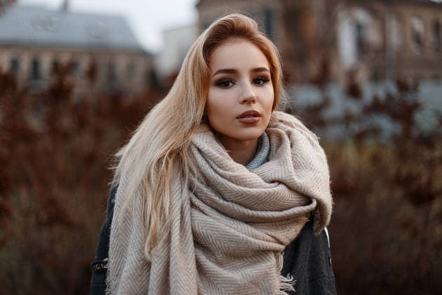 Porträt eines schönen, attraktiven jungen Mädchens in einem stilvollen schwarzen Mantel mit einem beigen Vintage-Schal, mit schwarzen Handschuhen und in einem Strickpullover vor dem Hintergrund von trockenem Gras. Stilvolles Mädchen. *** Portrait one beautiful, attractive Boys Girls in a stylish Black people Coat with a beige Vintage Scarf, with Black people Gloves and in a Knitted sweater before the Background from Trockenem Grass Stylish Girls 1102837096