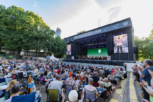 Klassik!Picknick mit dem Beethoven Orchester auf dem Kunst!Rasen Bonn Das Beethoven Orchester Bonn unter der Leitung von Generalmusikdirektor Dirk KAFTAN beim Open-Air-Konzert KLASSIK!PICKNICK auf dem Kunst!Rasen Bonn-Gronau. Das Sommerprogramm steht unter dem Motto Fußball - passend zur WM 2026. Die Konzertreihe findet am Rande der Rheinaue am Bonner Rheinufer statt. Bonn Gronau Nordrhein-Westfalen Deutschland *** Classical Picnic with the Beethoven Orchestra at the Kunst Rasen Bonn The Beethoven Orchestra Bonn, conducted by General Music Director Dirk KAFTAN, at the open-air concert CLASSICAL PICNIC at the Kunst Rasen Bonn in Gronau. The summer program’s theme is soccer, in keeping with the 2026 World Cup. The concert series takes plac Copyright: xMarcxJohnx