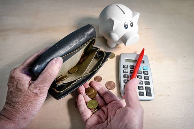 Alte Hände, die Münzen aus einer fast leeren Brieftasche zählen, ein Sparschwein und ein Taschenrechner mit einem roten Stift vor einem hellen Holzhintergrund; Konzept für eine unzureichende Altersrente Old hands counting coins from an almost empty wallet, piggy bank and calculator with a red pen on a light wooden background, concept for an insufficient retirement pension (License=RF) Copyright: xZoonar.com maren-winter.dex 25281786